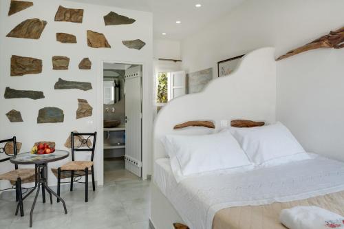 a bedroom with a bed and a table and chairs at Politimis Studio N2 in Amorgos