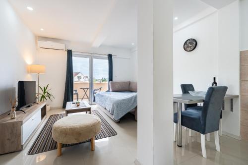 a bedroom with a bed and a desk with a table and a chair at Apartments Kankaras - Sea View in Tivat