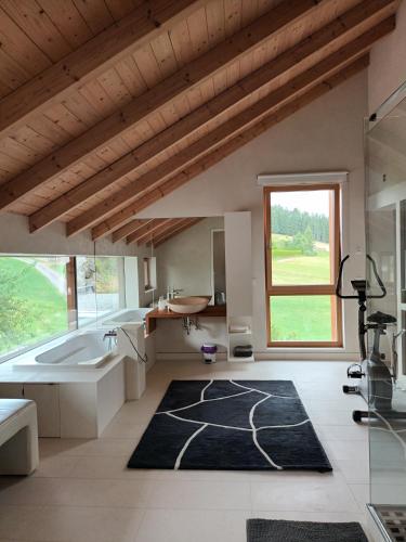 a bathroom with a tub and a large window at Haus am Teich mit privater Sauna in Sankt Leonhard bei Freistadt
