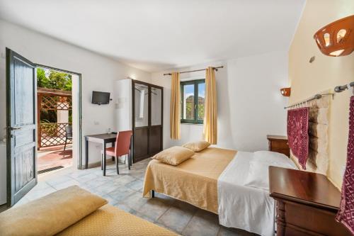 a bedroom with a bed and a desk and a table at Sa Funtana in Gonnesa