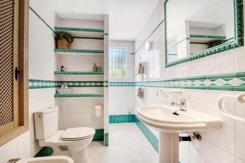 a bathroom with a white toilet and a sink at Casa Crystal in Jávea