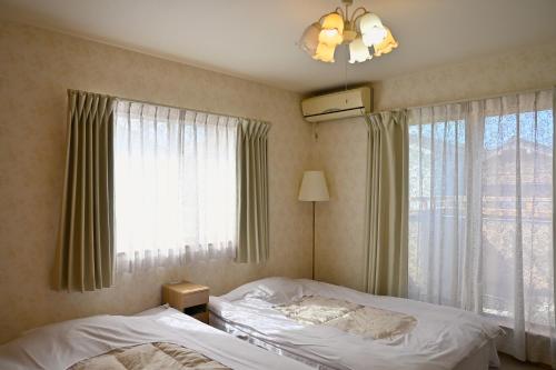a bedroom with two beds and a window at 心宿 伏見稲荷 in Kyoto
