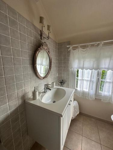a bathroom with a sink and a mirror at Chic et Charme Cottage in Suzay