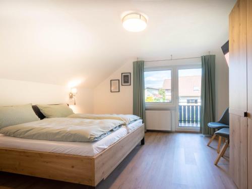 a bedroom with a bed and a large window at Ferienwohnung Weitblick in Durbach