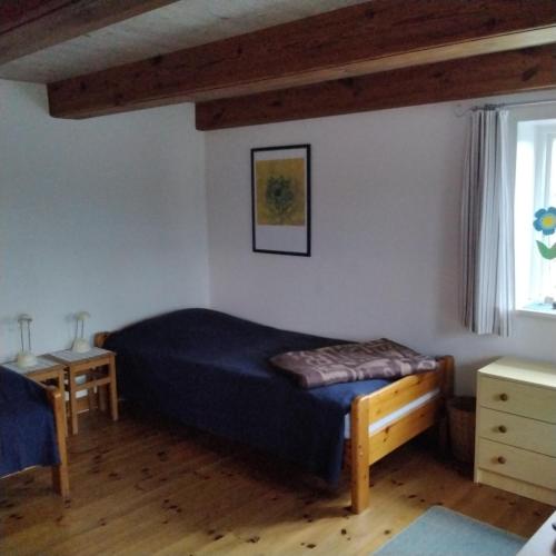 ein Schlafzimmer mit einem Bett, einem Tisch und einem Fenster in der Unterkunft Friesenhaus Anke in Struckum