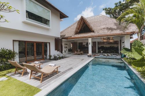 a villa with a swimming pool and a house at Villa Caz a Bali in Canggu