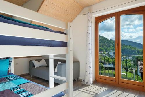 a bedroom with bunk beds and a balcony at Ferienwohnung Sulzberg, 103qm in Alpirsbach