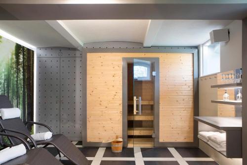 a room with a shower with a wooden door at Kurhaus Masserberg in Masserberg