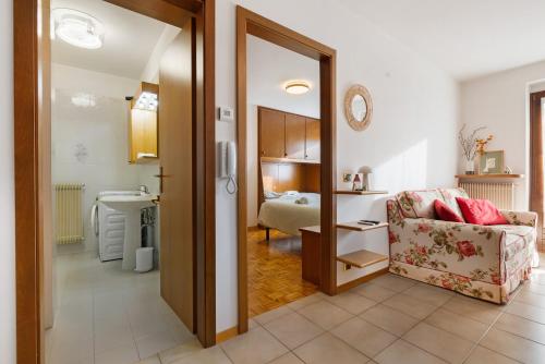 a living room with a chair and a bedroom at La finestra sui monti - Breguzzo in Breguzzo
