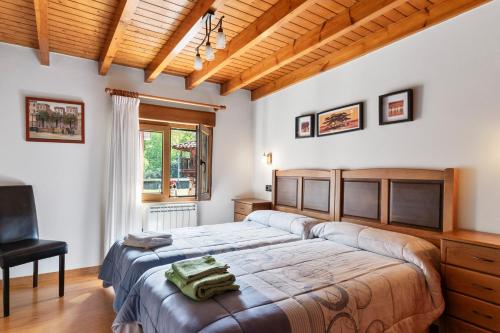 a bedroom with two beds and a desk at Huerta El Pozu in Soto de las Dueñas
