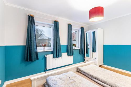 a bedroom with blue walls and windows at Ferienwohnung im Torwärterhäuschen in Rüthen