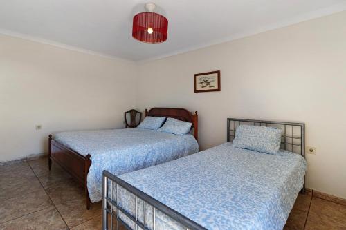 two beds sitting next to each other in a bedroom at Quinta Natureza de Coura in Paredes de Coura