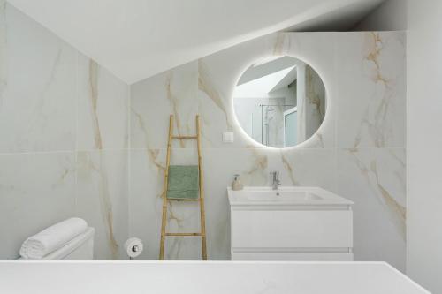 a white bathroom with a sink and a mirror at Casa Belavista in Gaula