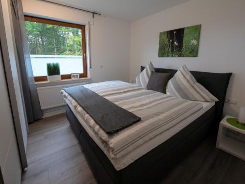 a large bed in a room with a window at Hof Weuste Fewo Lister in Attendorn