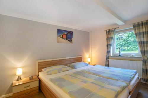 a bedroom with a bed with two lamps and a window at Ketelsens Ferienwohnung in Bohmstedt