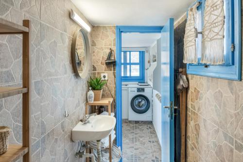 a bathroom with a sink and a washing machine at Avlona Blue in Diafani