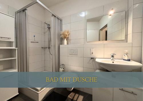 a bathroom with a sink and a shower with a mirror at Flexi Flats in Lingen