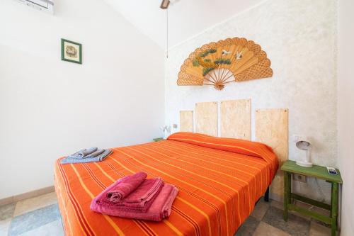 a bedroom with an orange bed with two towels on it at Villetta Stella in Chia