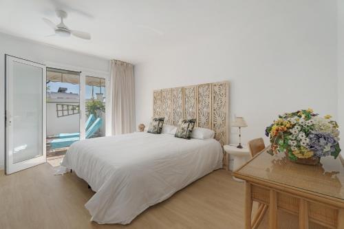 a white bedroom with a bed and a window at Villa Spinnaker Playa in Puerto de Santiago