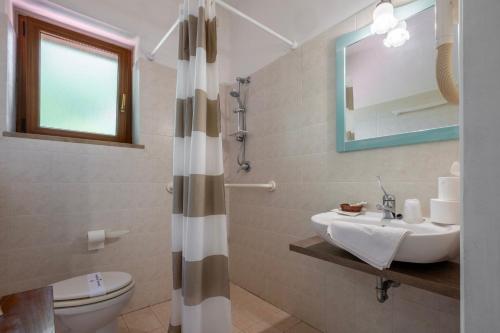 a bathroom with a sink and a toilet and a mirror at Rosaspina - Appartamento 7 in Capalbio