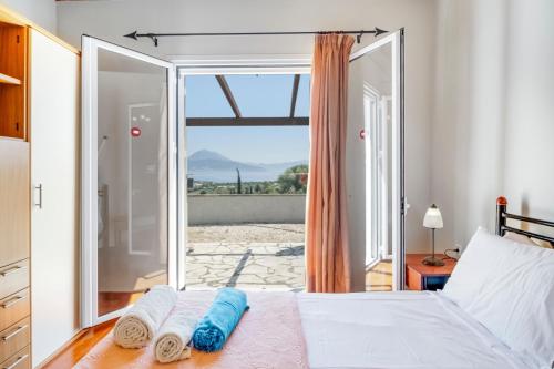 a bedroom with a bed and a large window at Villa Jimmy's Katomeri 3 in Meganisi