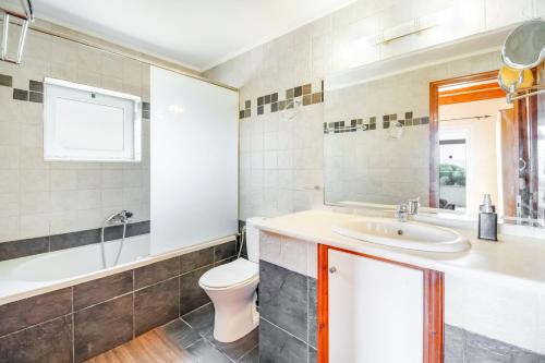 a bathroom with a sink and a toilet and a tub at Villa Jimmy's Katomeri 3 in Meganisi