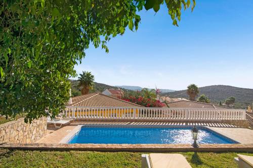 a swimming pool in a yard with a white fence at Villa Isabel in Loulé