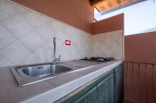 a kitchen with a sink and a stove at Jerà D72 Vista Mare in Vulcano