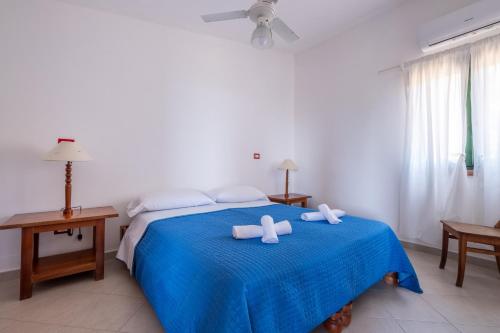 a bedroom with a blue bed with two towels on it at Jerà D72 Vista Mare in Vulcano