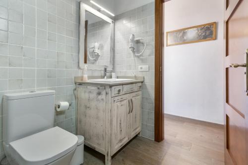 a bathroom with a white toilet and a sink at Volcán 16 in Tanque