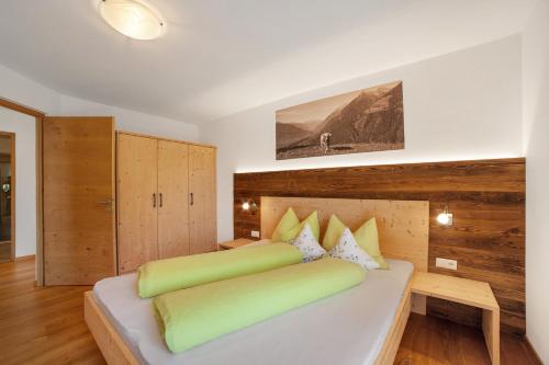 a bedroom with a large white bed with yellow pillows at Ederhof in Schenna