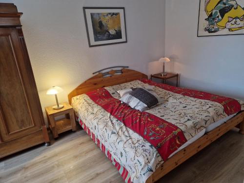 a bed in a bedroom with two night stands and two lamps at ehemaliges Gutsverwalterhaus in Mildenitz