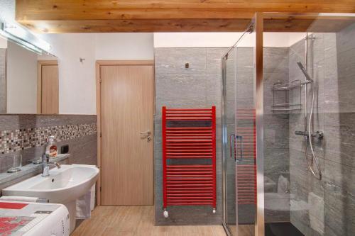 a bathroom with a shower with a red door at Ginepro Casa Vacanze in Madesimo
