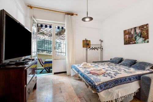 a bedroom with a bed and a flat screen tv at Casa Lulu' in Lavagna
