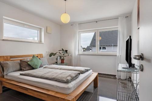a bedroom with a bed and two windows at Fewo Am Otterbach in Jockgrim