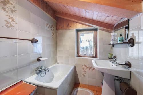 a bathroom with a tub and a sink at Villa Maria Auronzo in Auronzo di Cadore