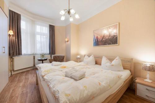 a bedroom with a large white bed with white pillows at Haus Margarete Christel Winkelmann in Cuxhaven