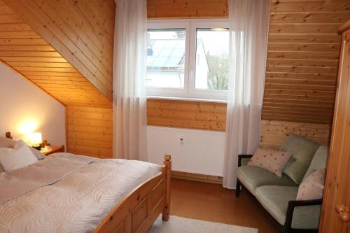 a bedroom with a bed and a window and a chair at Apartment Gartenblick in Korbach