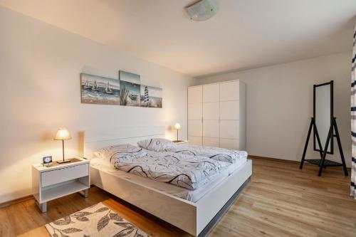 a bedroom with a large white bed and a table at Ferienhaus Dunklau in Wesselburen