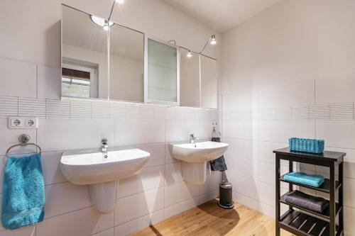 a bathroom with two sinks and mirrors on the wall at Ferienhaus Dunklau in Wesselburen