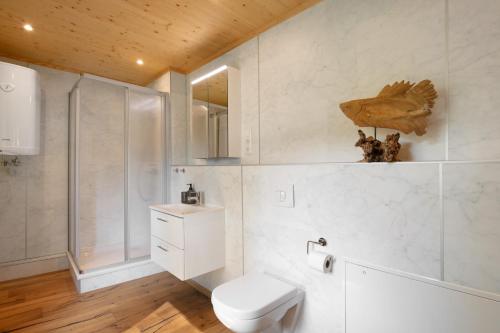 a white bathroom with a toilet and a sink at Ferienhaus Im Teichland Linum in Fehrbellin