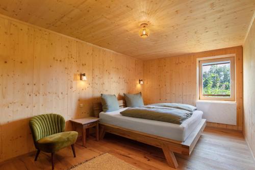 a bedroom with a bed and a chair and a window at Ferienhaus Im Teichland Linum in Fehrbellin