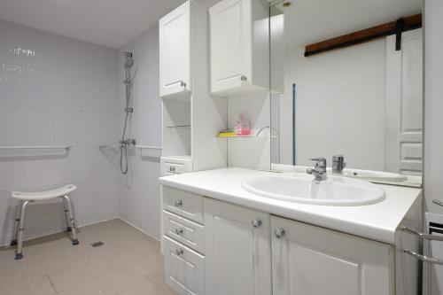 a white bathroom with a sink and a shower at Au Fil De L'eau in Chein-Dessus