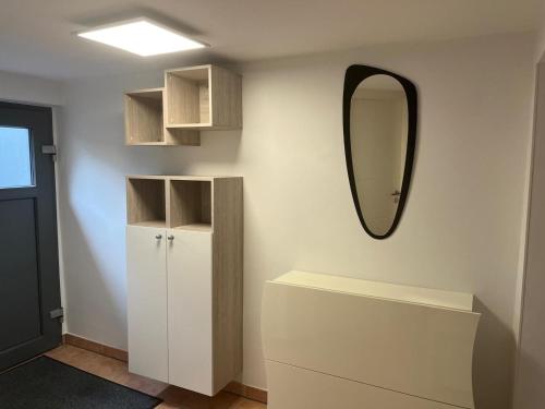 a bathroom with a mirror and a white cabinet at Ferienwohnung Bauer in Puschendorf
