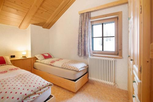 a bedroom with two beds and a window at Appartamento Gemma in Livigno