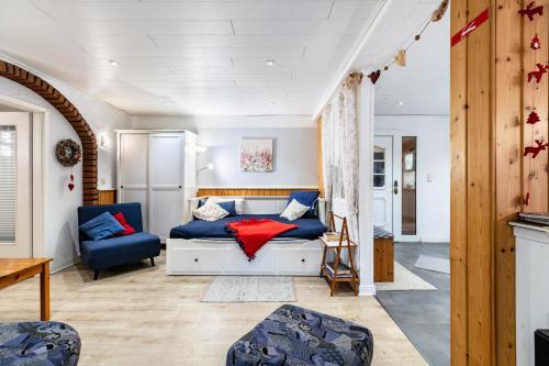 a bedroom with a bed and a blue chair at Hof Islandpferde von der Holstenau in Eggstedt