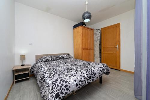 a bedroom with a black and white bed and a wooden door at Au Fil De L'eau in Chein-Dessus