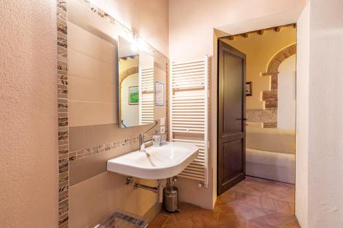 a bathroom with a sink and a mirror and a tub at Podere Spagliarda in San Quirico dʼOrcia