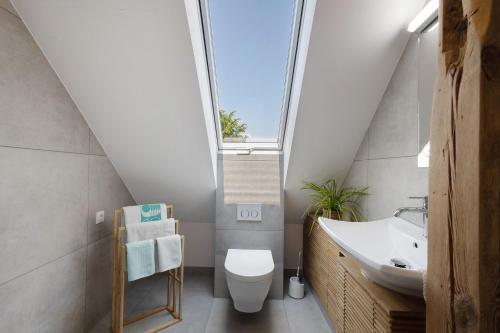 a bathroom with a toilet and a sink and a window at Ferienwohnung Skyline Suite in Bayreuth