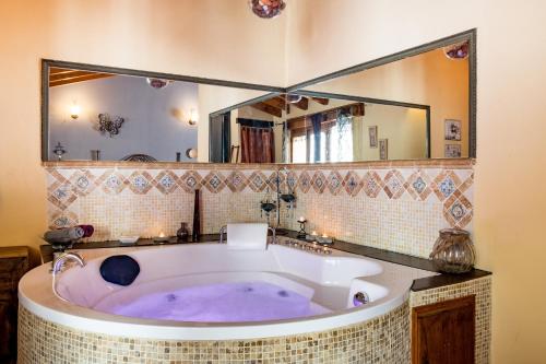 a bath tub in a bathroom with a large mirror at La Tarabilla in Casas del Abad